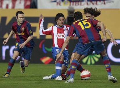 Agüero intenta escaparse de Edmilson, Puyol e Iniesta.