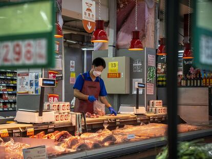 Un comerciante corta la carne en un supermercado en Pekín.