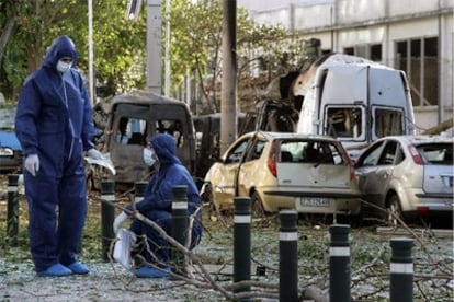 Dos policías buscan pistas junto al lugar de la explosión en la Bolsa de Atenas.