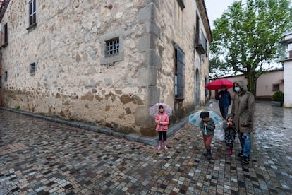 Una familia pasea por el centro de Òrrius, en el Maresme.