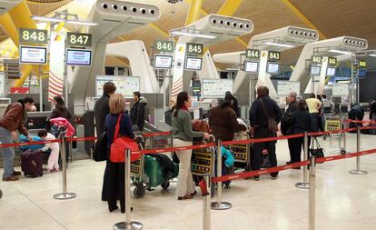 Un grupo de pasajeros hace cola para facturar el equipaje en la terminal 4 de Madrid-Barajas.