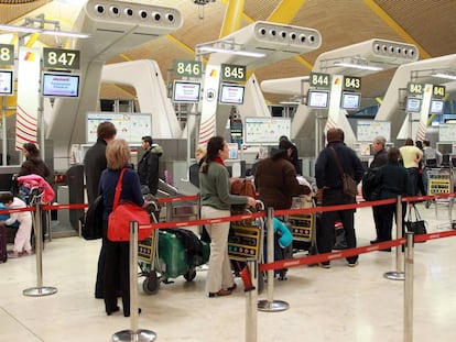 Un grupo de pasajeros hace cola para facturar el equipaje en la terminal 4 de Madrid-Barajas.