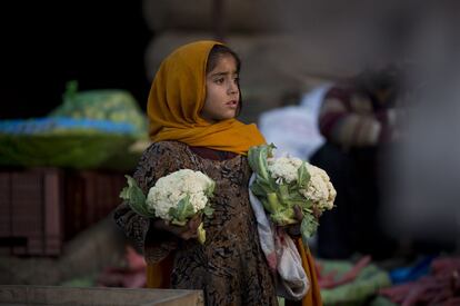 Una niña paquistaní vende coliflores en un mercado de frutas y hortalizas de Islamabad, en Pakistán.