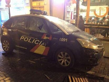 Un coche de policía, con las lunas rotas tras los disturbios.