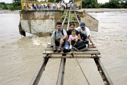 En la imagen, varias personas son evacuadas tras quedar seriamente dañado el puente de Ciudad Hidalgo (Chiapas), en la frontera de México con Guatemala.