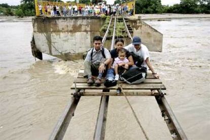 En la imagen, varias personas son evacuadas tras quedar seriamente dañado el puente de Ciudad Hidalgo (Chiapas), en la frontera de México con Guatemala.