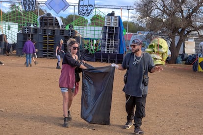 En la imagen Yanira y Ramiro, de Almería, recogen la basura generada durante la fiesta.