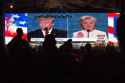 Pessoas acompanham em um telão, em West Hollywood, a transmissão do debate entre os dois candidatos em 19 de outubro.