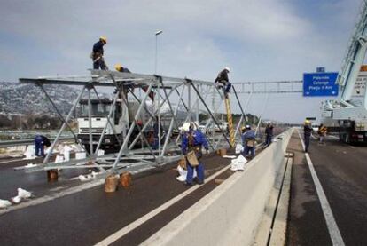 Operarios de Endesa tratando de reparar una línea eléctrica caída en la autovía a la altura de Platja d'Aro (Baix Empordà).
