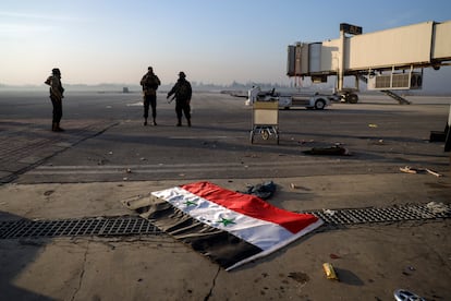 A Syrian flag is thrown onto the runway of Aleppo airport after it was captured by rebels on Monday.