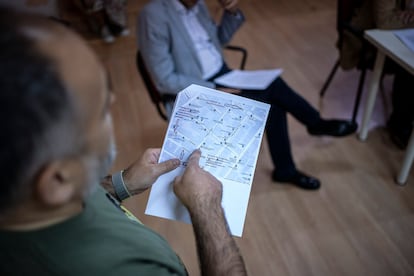 Uno de los asistentes a la reunión con el comisario y la delegada muestra el mapa de narcopisos que ha elaborado.
