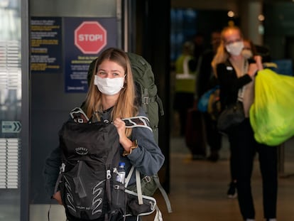 Una joven se protege del coronavirus con una mascarilla.