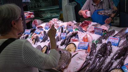 Una mujer compra en una pescadería en un mercado de Madrid.