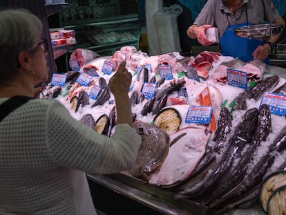 Una mujer compra en una pescadería en un mercado de Madrid esta semana.