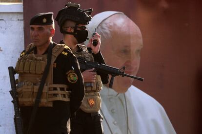 Agentes de seguridad esperan la llegada del Pontífice a la iglesia de Nuestra Señora de la Liberación, en Badgad. La seguridad será una de las claves del viaje. Francisco realizará todos sus desplazamientos en las ciudades que visitará a bordo de un coche blindado y cubierto (normalmente lo hace a bordo de un turismo corriente o subido a una suerte de vehículo descapotable).