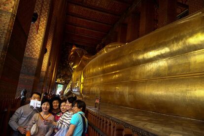 Un grupo de turistas chinos se sacan un selfi al lado del Buddha de Wat Pho, en Bangkok (Tailandia). 