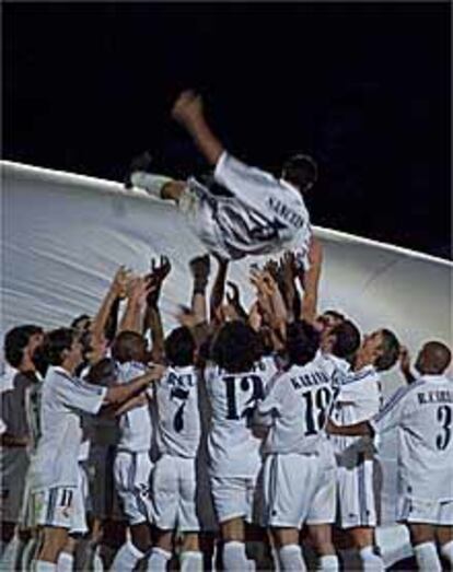 Los jugadores del Madrid mantean a Sanchis al final del partido.