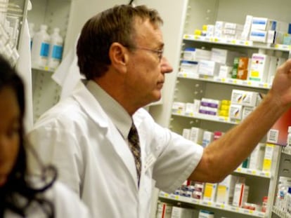 Un farmacéutico busca medicamentos en la rebotica.