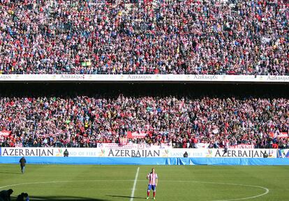 Torres, en el centro del campo, saluda a los aficionados del Atlético de Madrid.