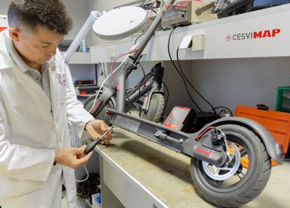 Un trabajador de un centro de investigación de Mapfre analiza la batería de un patinete eléctrico.