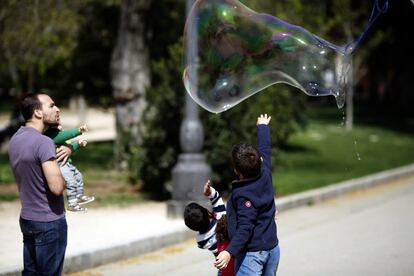 Unos niños juegan con una pompa de jabón gigante en el parque de El Retiro de Madrid.