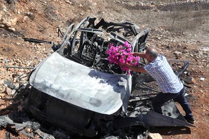 Samir Ayoub, tío de tres niños que murieron en un ataque aéreo israelí, colocaba flores en un automóvil calcinado en la localidad de Ainata, una aldea libanesa fronteriza con Israel.