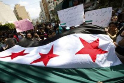 Manifestantes anti-El Asad ondean una antigua bandera siria este viernes en Beirut (Líbano).