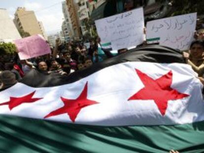 Manifestantes anti-El Asad ondean una antigua bandera siria este viernes en Beirut (L&iacute;bano).