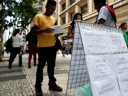 Pessoas procuram vagas de empregos em cartazes no centro de São Paulo.