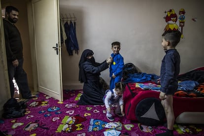 Hanan, la madre, ayuda a sus hijos a vestirse para ir al colegio jordano mientras Shams, la bebé, juega. La mayoría de personas que han huido del conflicto sirio no viven en los campos de refugiados sino en las zonas más deprimidas de la ciudad.