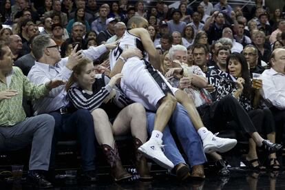 El jugador de los Spurs de San Antonio Tony Parker cae sobre el p&uacute;blico persiguiendo un bal&oacute;n en el partido de baloncesto disputado contra los Portland Trail Blazers. San Antonio se impuso por 114 a 97.