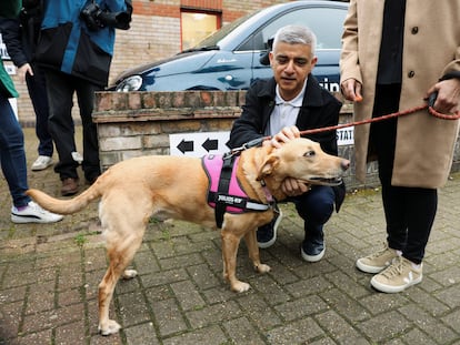 El alcalde laborista de londres, Sadiq Kahn, acaricia a su perra Luna a las puertas de un colegio electoral, este jueves