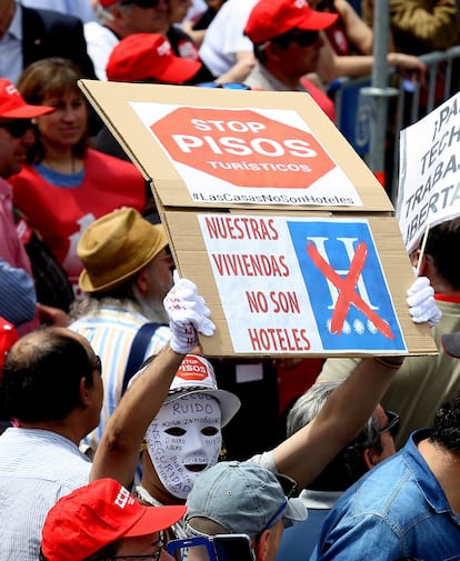 Un hombre sostiene un cartel bajo el lema "Stop pisos turísticos" durante la manifestación del Primero de Mayo, en Madrid.