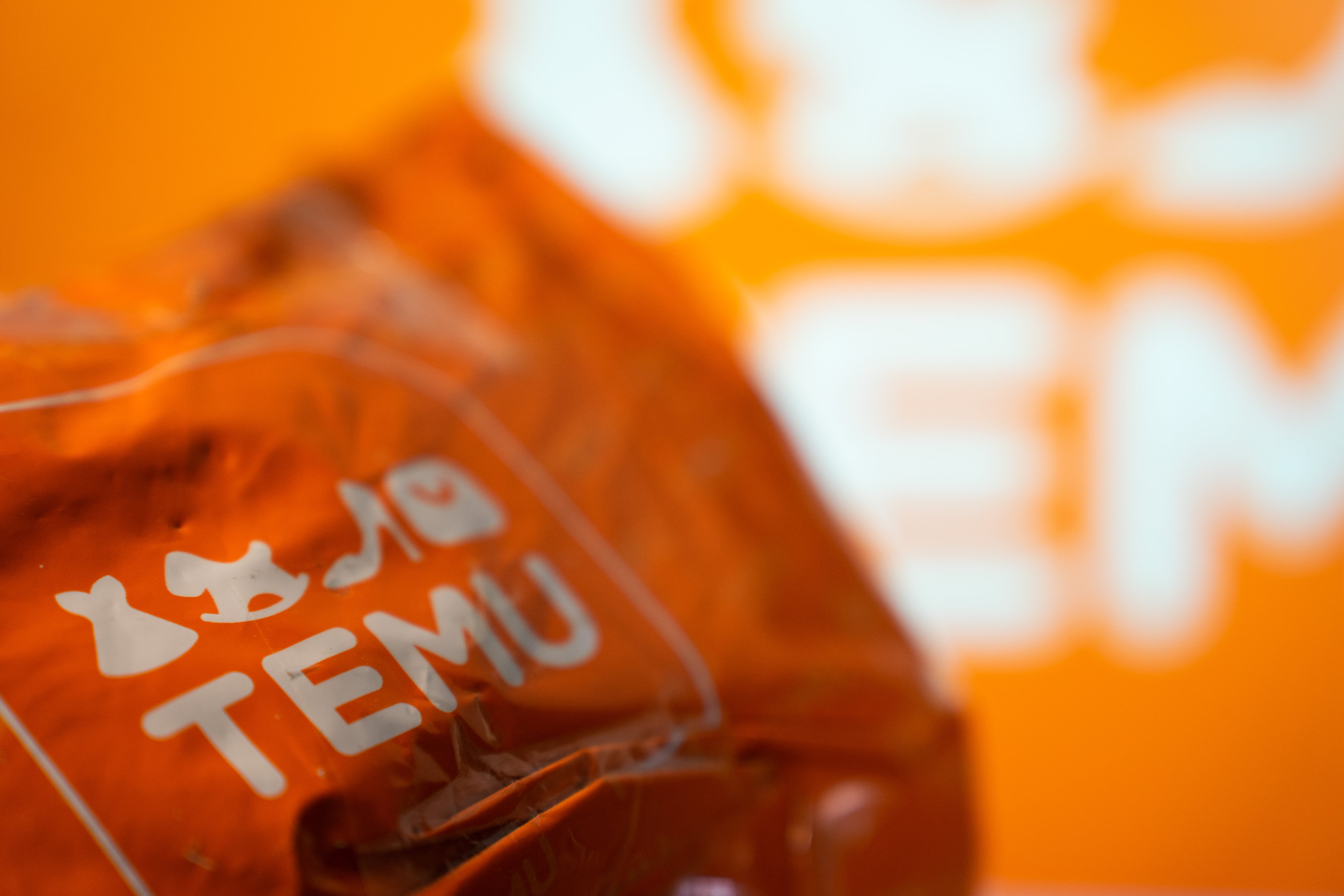 A package from Temu is seen in front of a screen with the Temu logo. (Photo by Nikos Pekiaridis/NurPhoto via Getty Images)