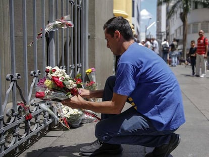 Um homem deixa flores para as vítimas da Catedral de Campinas.