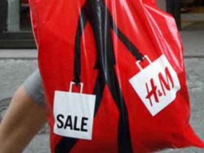 Una persona con una bolsa de Hennes and Mauritz (H&M)