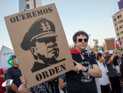 Un hombre sostiene un cartel con el rostro de Augusto Pinochet en una protesta a favor de la policía el 6 de abril 2023 en Santiago, Chile.