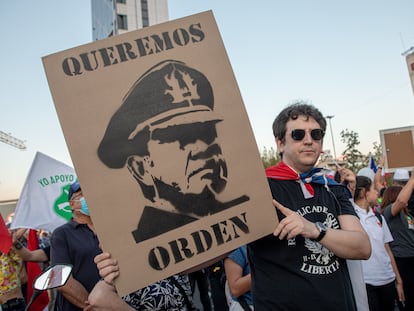 Un hombre sostiene un cartel con el rostro de Augusto Pinochet en una protesta a favor de la policía el 6 de abril 2023 en Santiago, Chile.