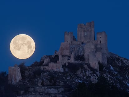 La luna llena aparece por detrás del castillo Rocca Calascio, en Italia, el 7 de marzo de 2023.