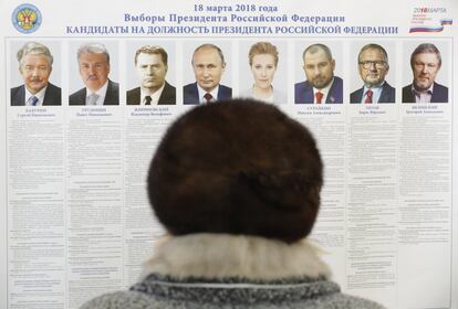 Una mujer rusa observa la lista de los candidatos que concurren a la presidencia de Rusia, en un centro electoral de Sovkhoz Imeni Lenina.