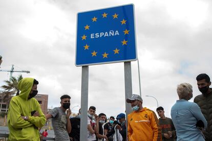 Varios migrantes esperan para pasar la frontera entre Ceuta y Marruecos voluntariamente.