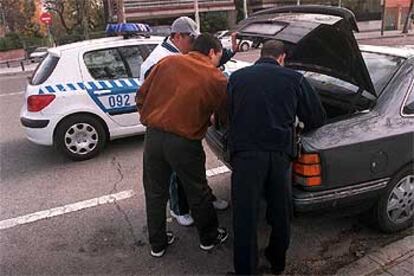 Un policía inspecciona el maletero del coche de un rumano, en la plaza de la Madre Molas.