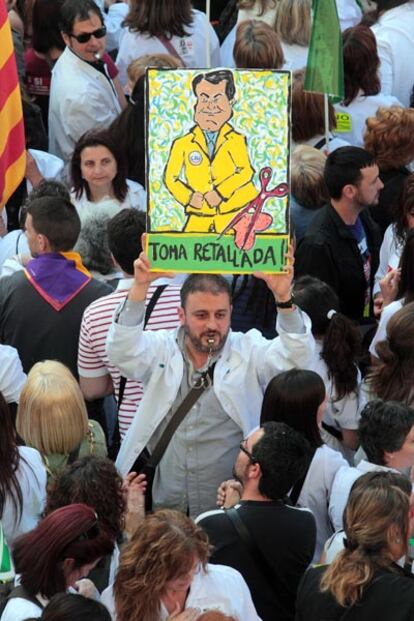 Un médico, con pito en la boca y una pancarta en mano protesta contra los recortes presupuestarios en los servicios públicos previstos por el Gobierno de CiU en Cataluña.
