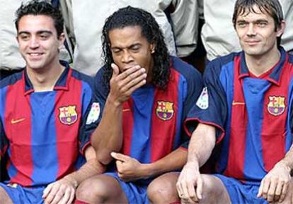 Ronaldinho bosteza entre Xavi y Cocu durante la toma de la foto oficial de la plantilla ayer.