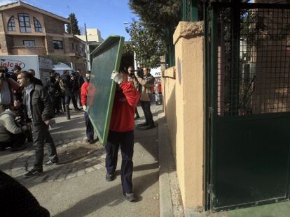 Un operario devuelve una de las pizarras embargadas al colegio privado Santa Illa.