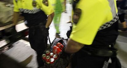 Agentes de la Guardia Urbana de Barcelona con latas intervenidas en La Rambla.