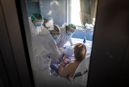 Unos sanitarios atienden a una persona ingresada en la UCI del Hospital Clinico de Valencia.