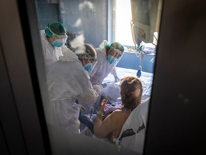 Unos sanitarios atienden a una persona ingresada en la UCI del Hospital Clinico de Valencia.