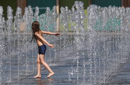 Un niño juega con chorros de agua en un día de calor en Moscú, Rusia. 
