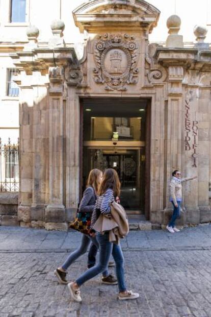 Estudiantes pasan junto al edificio de la Universidad Pontificia de Salamanca.